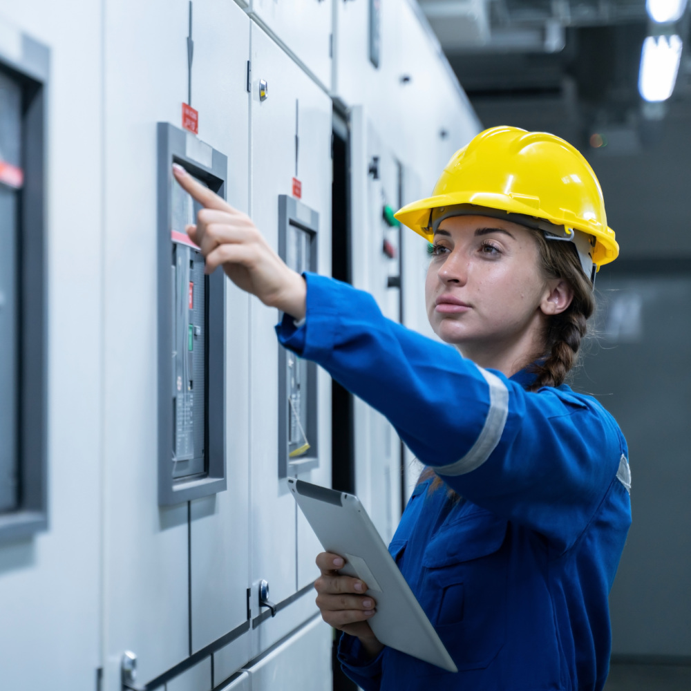 Woman Electrical Engineer working front HVAC control panels, Tec